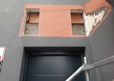 izolačná vrstva fasády s veľkými dierami nad vchodovými dverami