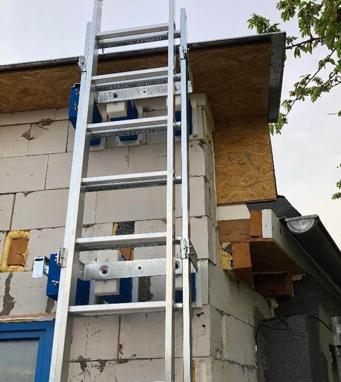 žebřík upevněný na modrých montážních blocích PROPASIV na stavbě